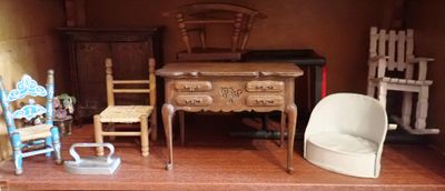 une maison de poupées dans laquelle se trouvent un bureau et des chaises