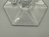 a clear glass ashtray with a silver lid on a white table