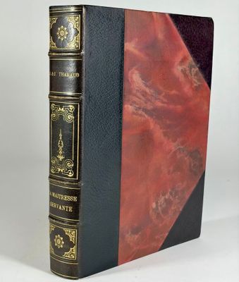 un livre noir et rouge posé sur une table blanche