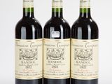 trois bouteilles de vin rouge posées l'une à côté de l'autre sur une surface blanche