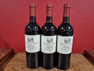 three bottles of wine sit on a wooden table in front of a red wall