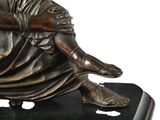 a bronze statue of a man sitting on a black base