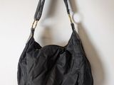 the black bag is hanging on a hook on the wall