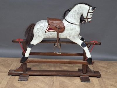 a wooden rocking horse with a saddle on it ' s back