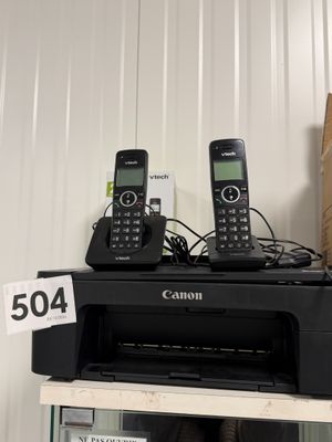 two phones sitting on top of a printer on a shelf