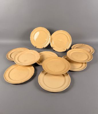 un lot de six assiettes plates jaunes posées sur un support gris