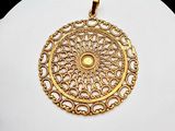 a white plate with a gold pendant on it
