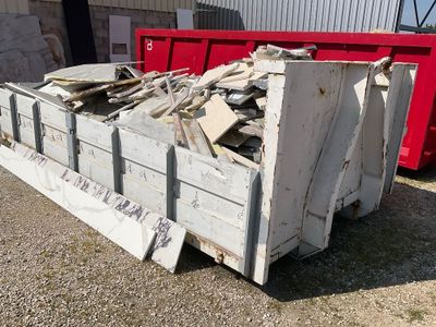 Une benne à gravats type ampliroll ( remplie de gravats)