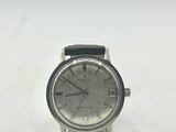 un gros plan d'une montre sur une surface blanche avec un fond blanc