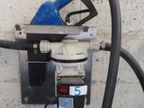 une pompe à essence fixée au mur, à côté d'un tuyau