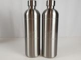 two stainless steel water bottles sitting on a white surface