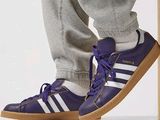 un homme debout sur un tabouret, chaussé d'une paire de chaussures
