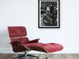 a picture of a man sitting on a chair in front of a picture of a woman