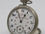 a silver pocket watch sitting on top of a white table
