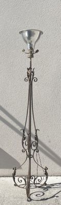 a lamp that is sitting on the ground next to a wall