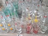 bottles and glasses on a table in a store with a price tag