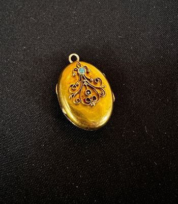 un gros plan d'une boucle d'oreille en or sertie d'une pierre bleue