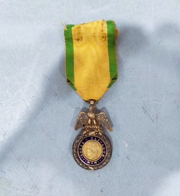 an image of a medal with a gold eagle and a green ribbon