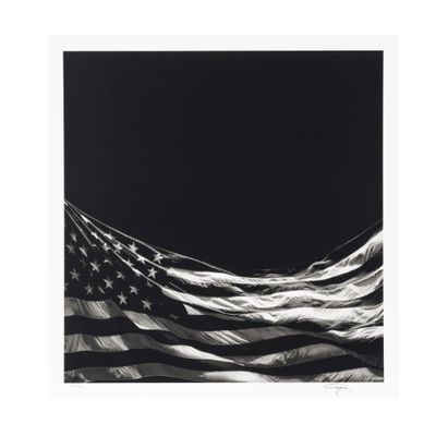 une photo en noir et blanc d'un drapeau américain sur fond noir