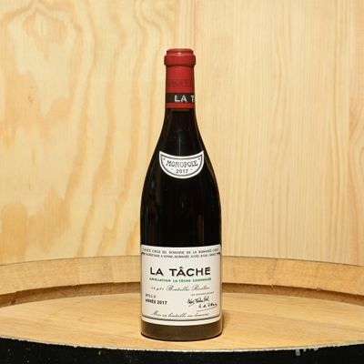 a bottle of wine sitting on top of a barrel