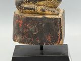 statue of a seated buddha on a black base on a gray background