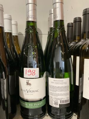 plusieurs bouteilles de vin sont alignées sur une étagère dans un magasin