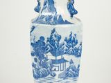 un vase bleu et blanc orné d'un paysage de montagne