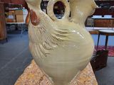 un vase blanc orné d'un oiseau, posé sur une table