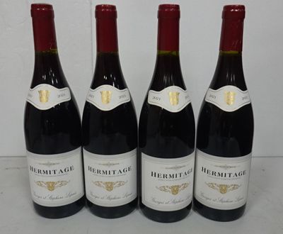 four bottles of red wine are lined up on a table