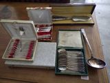 a table with silverware on it and a box with spoons