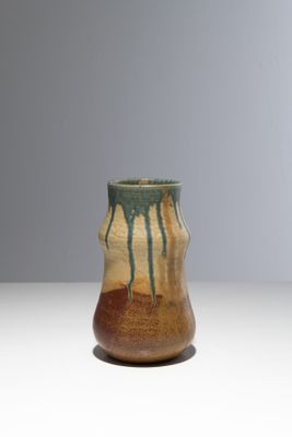 un vase marron et vert posé sur une table