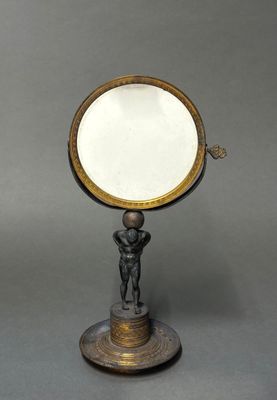 une plaque en laiton ancien surmontée d'un miroir