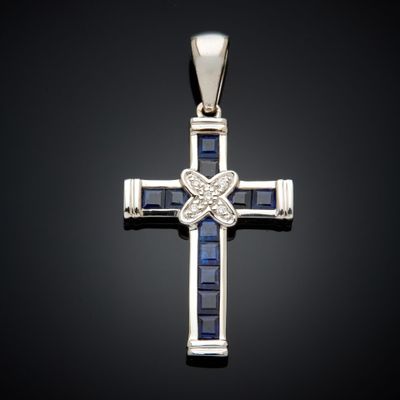 un gros plan d'une croix ornée de pierres bleues sur fond noir