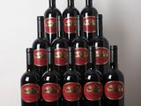 des bouteilles de vin rouge sont posées sur une table en bois devant un mur blanc