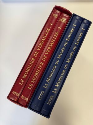 trois livres sont empilés sur une table