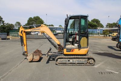 une petite excavatrice garée sur un parking