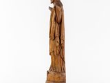a wooden statue of a man holding a cigarette in his hand