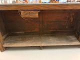 an old wooden cabinet with a drawer underneath it