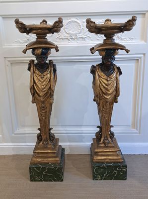 pair of antique bronze figurines of women with hats on their heads
