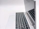 a silver laptop with a black keyboard on a white surface