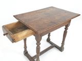 une vieille table en bois avec un tiroir en dessous, posée sur un plan de travail blanc