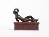 statue of a woman laying on a marble block