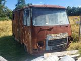 une vieille camionnette rouillée garée dans un champ