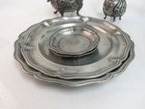 a silver plate on a white table with a silver bird on it