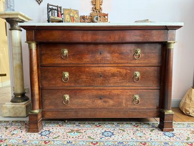 une commode en bois avec un plateau en marbre, posée sur un tapis