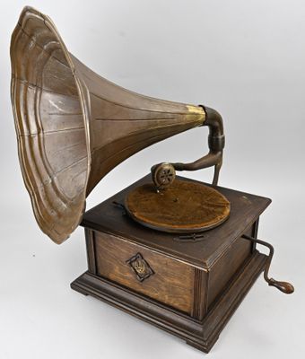 un vieux gramophone posé sur un support en bois, avec un fond blanc
