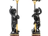 pair of black and gold candlesticks with cherenshes on stands
