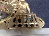 a gold clock that is sitting on top of a table