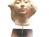 sculpture d'une tête de femme sur une base en bois