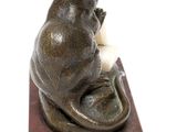 statue of a cat sitting on top of a marble block